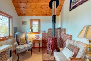 a living room with a wood stove and chairs at Beautiful hilltop home with deck & view of Penobscot Bay - near festivals & more in Rockport