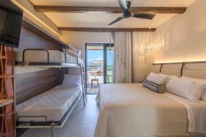a bedroom with two bunk beds and a balcony at Zefyria Luxury Suites in Zefiría +129 photos