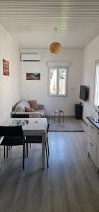 a living room with a couch and a table at Beau logement avec terrasse, jacuzzi et terrain de pétanque privatif à 5 minutes de la plage in Audenge