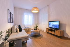 a living room with a couch and a flat screen tv at 'Elan Suites in Preveza