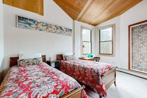 a bedroom with two beds and two windows at Private Oceanfront Home -- 2 Fireplaces, 4 Decks & Grill, Dog-friendly in East Boothbay