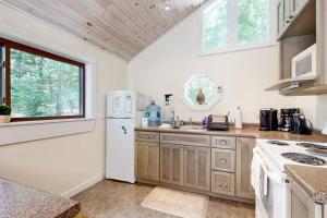 a kitchen with a white refrigerator and a sink at Geodesic Dome w/ Riverfront Deck, Lovely Views, & High-Speed WiFi - Dogs Welcome in Boothbay +19 photos