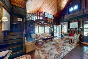 a living room with a staircase in a house at Spacious Waterfront Estate & Cabins W/ Porch, Fireplace, Kayaks & Free WiFi in Brunswick