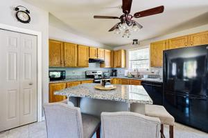 a kitchen with wooden cabinets and a black refrigerator at Charming cottage near the beach with balcony, deck, grill, fireplace - dogs OK in Georgetown
