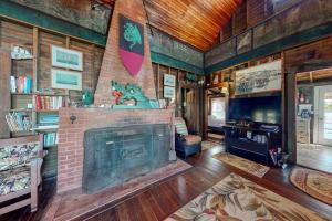 a living room with a brick fireplace in a house at Spacious Waterfront Estate & Cabins W/ Porch, Fireplace, Kayaks & Free WiFi in Brunswick
