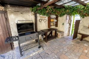 an outdoor kitchen with a grill and a table at Apartmány Havana in Český Krumlov