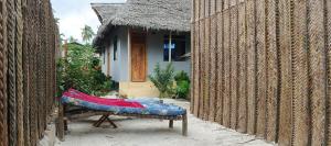 a bed sitting in front of a house at Zamani Matemwe House in Matemwe
