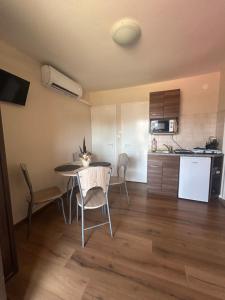 a kitchen and dining room with a table and chairs at Summer Apartments in Tiszakécske