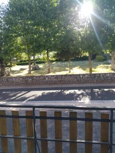 a view of a street with trees and a fence at Les sources de la Loire 2 in Sainte-Eulalie