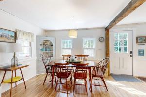 a kitchen and dining room with a table and chairs at Charming Boothbay Harbor cottage with partial AC, full kitchen, and sun room in Boothbay Harbor