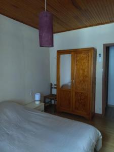 a bedroom with a bed and a wooden cabinet at Les sources de la Loire 2 in Sainte-Eulalie