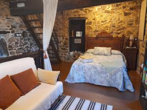 a bedroom with a bed and a couch at Vega in Muñás