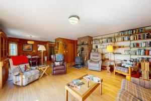 a living room filled with furniture and a fireplace at Waterfront stay with scenic deck, grill, smart TVs, shore access - dog-friendly in Penobscot