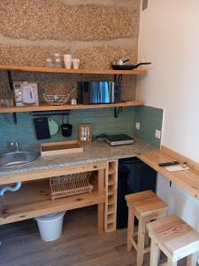 a kitchen with a counter with a sink and wooden shelves at Quinta Pedra do Rio - Lérias in Salvador do Monte