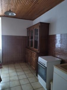 a kitchen with a stove and a cabinet in it at Les sources de la Loire 2 in Sainte-Eulalie