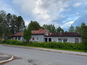 a white house with a red roof on the side of a road at YKI Room in Oulu