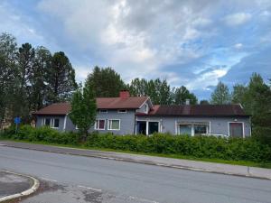 a white house with a red roof on the side of the road at YKI Room in Oulu +14 photos