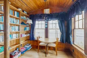 a dining room with a table and chairs and bookshelves at Dog-friendly, bayfront home - gorgeous ocean views, private balcony & fireplace in East Boothbay
