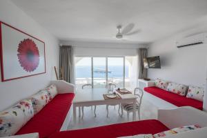 a living room with a red couch and a table at Eagles Nest Mykonos Suites & Apartments - Shared Pool & Jacuzzis in Mikonos