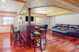 a living room with a bar and a leather couch at Tranquil Haven | Secluded waterfront house with sauna, dock, kayaks, canoe, gym in Greenville