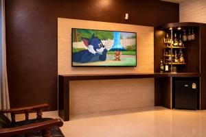 a room with a television with a cat on the screen at Shiva Apartments & Stud!os GOA in Parra