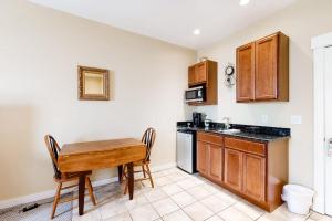 a small kitchen with a wooden table and a table at Lovely downtown Northeast Harbor suite near the water and near Acadia in Northeast Harbor