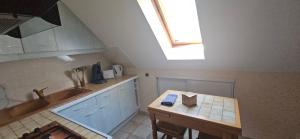 a kitchen with a table and a skylight at Le logis de l'Ajolaise in Vielle-Aure +8 photos
