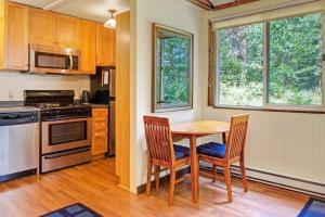 a kitchen with a wooden table and two chairs at Woodland Home near Long Pond w/ Spacious Living Area, Full Kitchen & Deck in Somesville