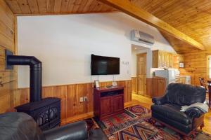 a living room with a stove and a chair at Charming dog-friendly studio cabin with firepit and near outdoor fun in Northport