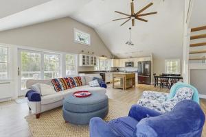 a living room with a couch and chairs and a kitchen at Modern farmhouse with deck, firepit, & balcony in Northport