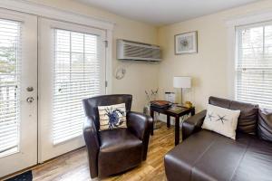 a living room with two chairs and a couch and a table at Water-view condo at Sheepscot Harbour Resort with deck, full kitchen, and WiFi in Edgecomb