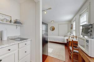 a kitchen with a refrigerator and a bedroom with a bed at Downtown, ground floor studio near the ocean w/patio, outdoor dining area & more in Wiscasset +11 photos