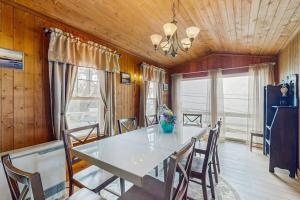 a dining room with a white table and chairs at Dog-friendly, bayfront home - gorgeous ocean views, private balcony & fireplace in East Boothbay