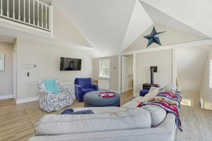 a living room with a gray couch and blue chairs at Modern farmhouse with deck, firepit, & balcony in Northport