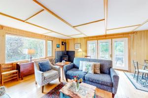 a living room with a blue couch and chairs at Dog-friendly ocean-view duplex with wood stoves, decks, grills, kitchens, ACs in Southwest Harbor +42 photos