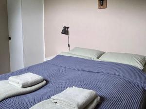 a bed with two towels on top of it at Fjordside Apartment in Åndalsnes