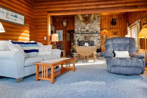 a living room with a couch and a chair and a table at Vintage lakefront cabin with incredible water views, private dock & pebble beach in The Highlands