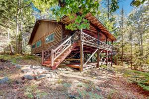 a large log cabin in the woods with a staircase at Stunning log cabin with fireplace & nature views - near shopping & dining in Boothbay Harbor