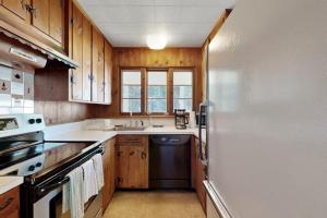 a kitchen with wooden cabinets and a refrigerator at Beachfront Delight with detached guesthouse, private beach access, Dog-friendly in Southport +21 photos