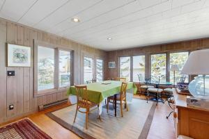 a dining room with a green table and chairs at Beachfront Delight with detached guesthouse, private beach access, Dog-friendly in Southport