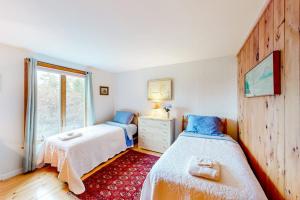 a bedroom with two beds and a window at Dog-friendly 3-story home with wood stove, deck, grill, ocean views, W/D, AC in Southwest Harbor