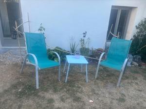 two chairs and a table in front of a house at Ty Lochois in Loches