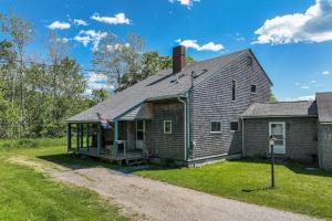 an old brick house with a flag on it at Waterfront stay with scenic deck, grill, smart TVs, shore access - dog-friendly in Penobscot