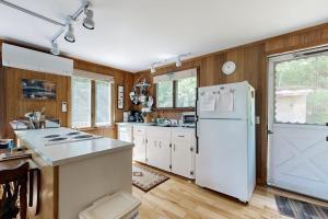 a kitchen with white appliances and a white refrigerator at Lady Slipper Cottage: Charming Lakefront Retreat with Canoes, Kayaks, and Modern Comforts in Somesville +17 photos