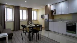 a kitchen and dining room with a table and chairs at Ardínia the Legend in Lamego