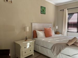 a bedroom with a bed with a nightstand and a window at SnaMel's in Waterfall