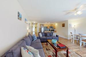 a living room with a couch and a table at Stylish Condo at Sheepscot Harbor Resort w/Free WiFi, River Views, & Balcony in Edgecomb