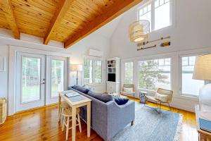 a living room with a couch and a table at Periwinkle Cottage | Sunny cottage in Westport Island overlooking the river in Westport