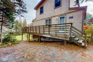 a house with a large deck on the side of it at Dog-friendly ocean-view duplex with wood stoves, decks, grills, kitchens, ACs in Southwest Harbor