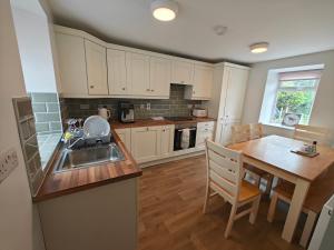 a kitchen with a table and a sink and a table and chairs at Maggies Cottage in Manorhamilton